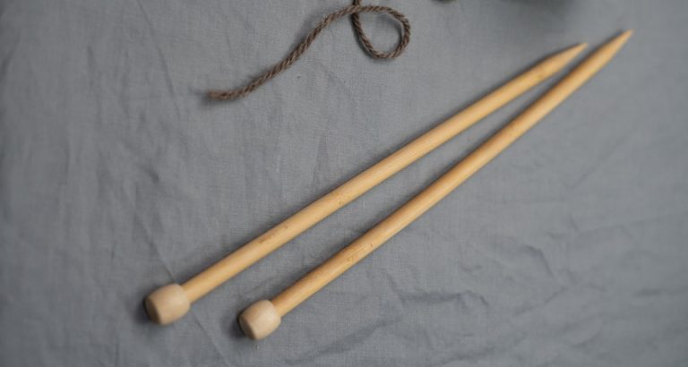 close-up-of-bamboo-knitting-needles-grey-background