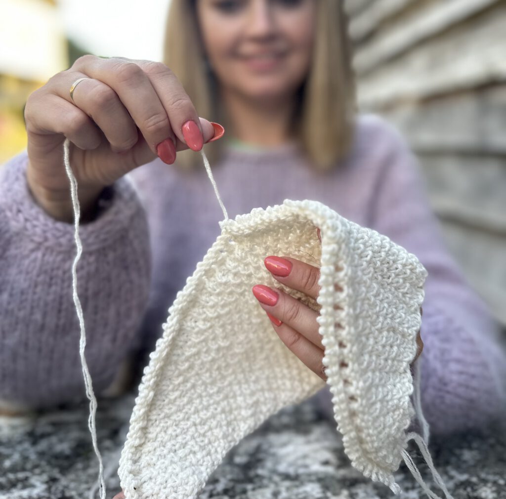 Woman unraveling knitting project