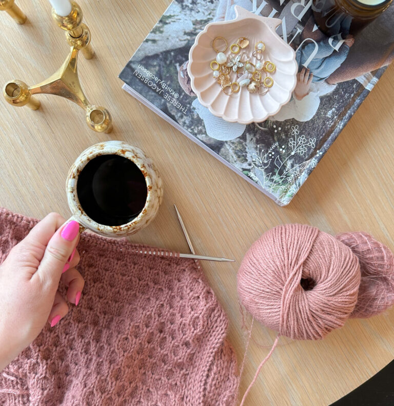 woman's hand holding coffee mug yarn ball knitting project