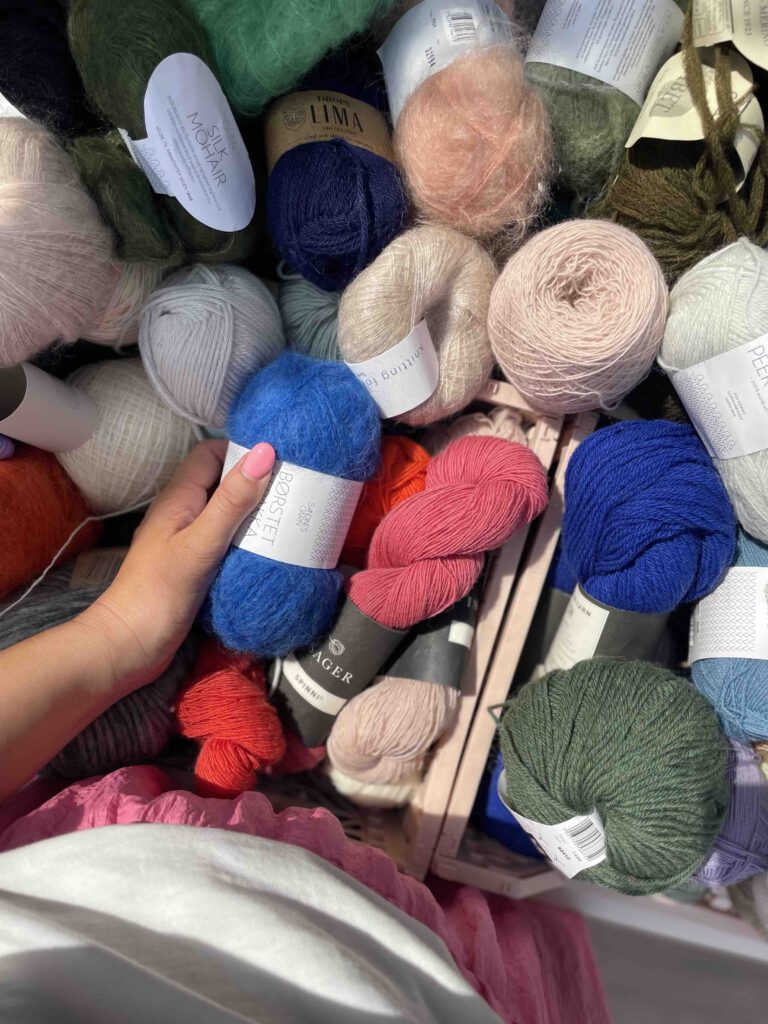 Aerial view of a big crate full of different yarns in various materials and colors.
