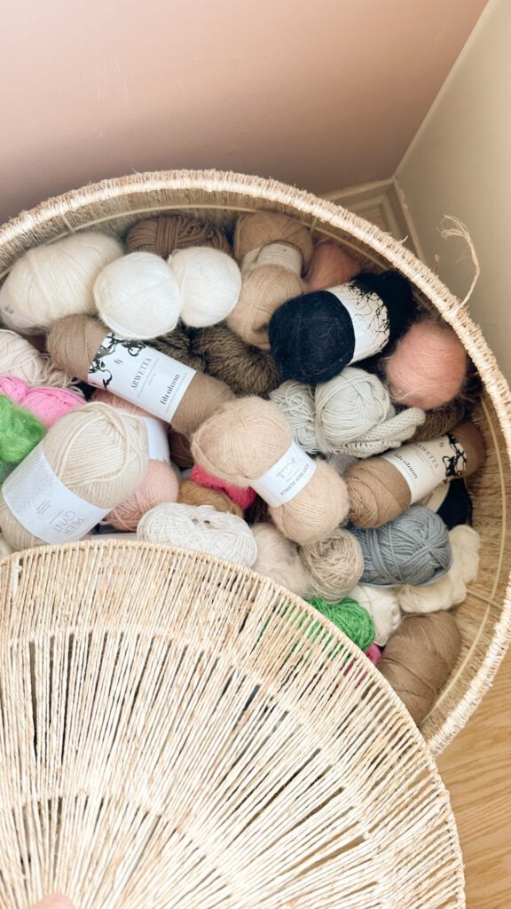 basket filled with yarn skeins in different colors