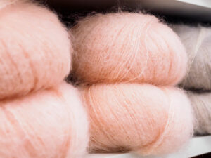 close up of pink and beige yarn skeins mohair